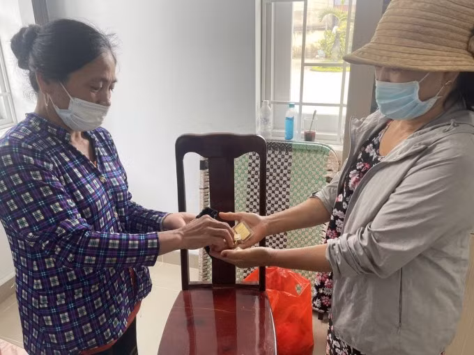 Bà Hương (trái) trả lại vàng cho người đánh rơi. Ảnh: Thái Hà