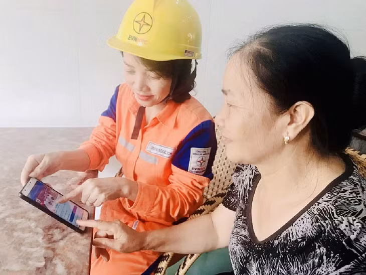 Nhân viên Điện lực Hạ Long hướng dẫn khách hàng sử dụng internet banking để thanh toán tiền điện hằng tháng.