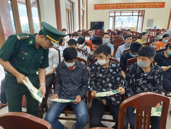 Cán bộ biên phòng phát tờ rơi tuyên truyền Luật Biên phòng cho cán bộ và người dân xã Đồng Văn (huyện Bình Liêu)
