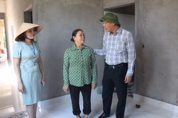 Đồng chí Trần Đức Thắng, Phó Bí thư Thị ủy, Chủ tịch UBND TX thăm, động viên hộ nghèo ở xã Liên Vị sau khi được hỗ trợ xây nhà mới.
