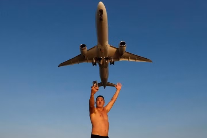 Ivan, một du khách đến từ Nga, chụp ảnh tự sướng ở bãi biển Mai Khao vào đúng lúc một chiếc máy bay cất cánh từ Sân bay Quốc tế Phuket ở Phuket, Thái Lan, ngày 17/1.