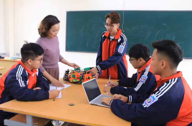 Vũ Xuân Long Đức (người đứng) cùng cô giáo hướng dẫn Định Thị Thúy Hường và các bạn trong nhóm cuộc thi “Sáng tạo Khoa học kỹ thuật quốc tế” thảo luận hình thành các ý tưởng sáng chế mới.