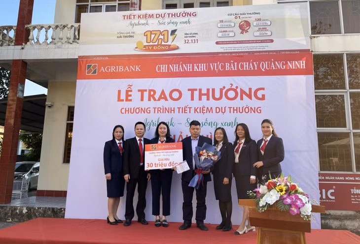 Anh Vũ Văn Thành, trú tại phường Việt Hưng, TP Hạ Long (thứ 4 từ trái sang) là khách hàng may mắn trúng thưởng giải nhì chương trình tiết kiệm dự thưởng “Agribank - Sức sống xanh”.