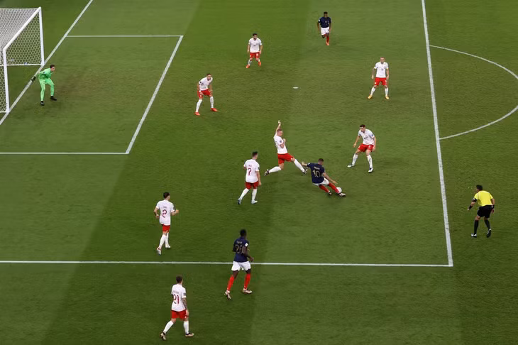 Mbappe dứt điểm trước vòng vây của các cầu thủ Ba Lan trên sân Al Thumama ngày 4/12. Ảnh: Reuters