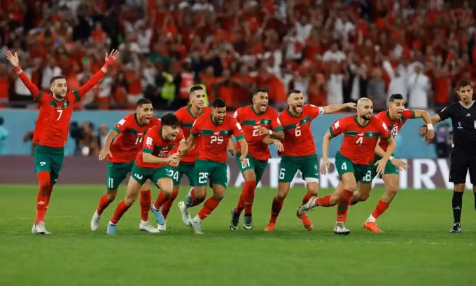 Các cầu thủ Morocco ùa chạy lên để mừng chiến thắng sau cú đá vào của Hakimi. Ảnh: Guardian