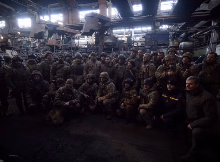 Tổng thống Ukraine Volodymyr Zelensky (không đội mũ, đứng giữa) chụp ảnh chung với các binh sĩ ở tiền tuyến Bakhmut, vào cuối tháng 12/2022. Ảnh: AP