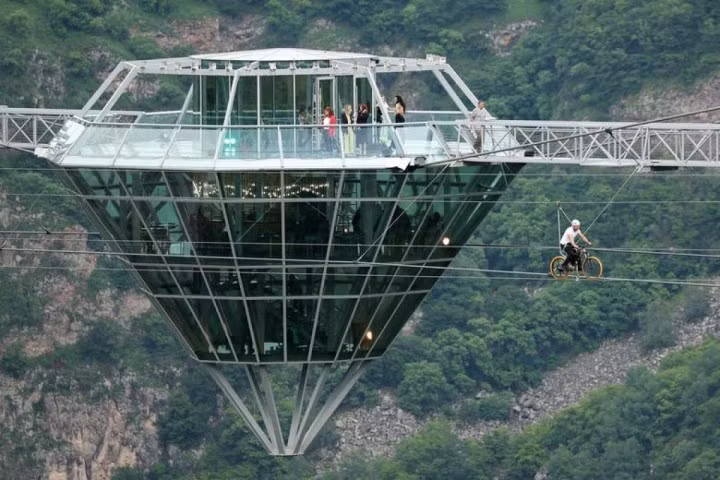 Một người đàn ông đạp xe trên đường zipline trong lễ khánh thành cây cầu kính bắc qua Dashbashi Canyon bên ngoài thị trấn Tsalka, Georgia, ngày 14/6.