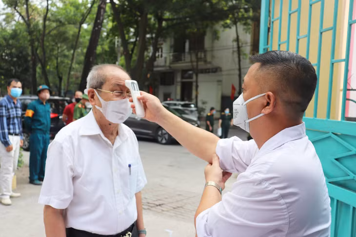 ...thực hiện đo thân nhiệt trước khi vào bỏ phiếu bầu cử.