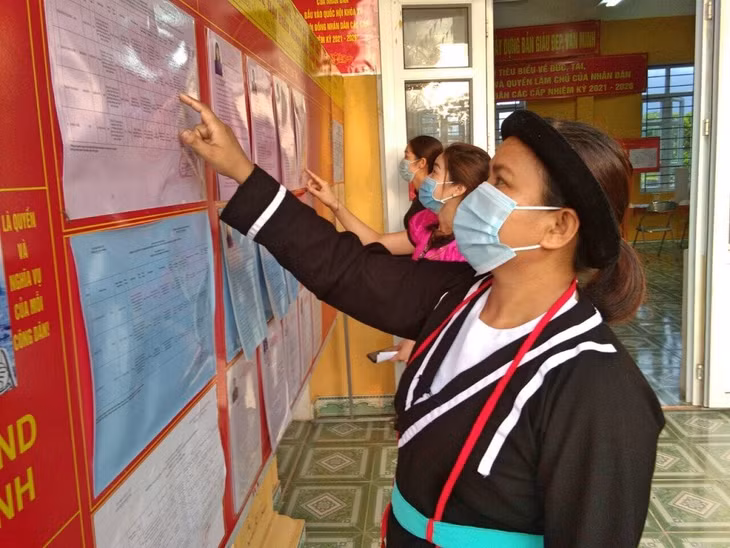 Cử tri bản Mào Liểng, xã Quảng Lâm, huyện Đầm Hà, tìm hiểu thông tin về các ứng cử viên trước khi bỏ phiếu.