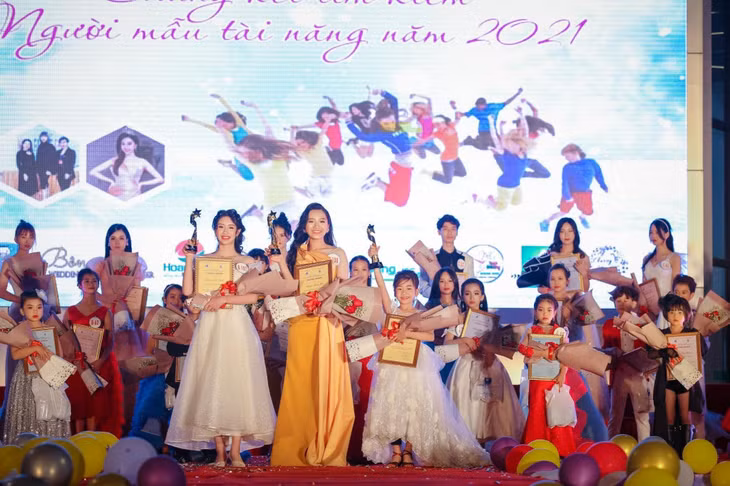 Nguyễn Hoàng Bảo Nhi (bên trái, hàng đầu) nhận giải quán quân Cuộc thi Tìm kiếm người mẫu tài năng 2021.