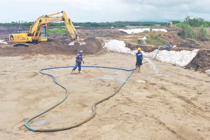 Nhà thầu thực hiện phun nước đắp cát tại vị trí nền đường đất yếu.