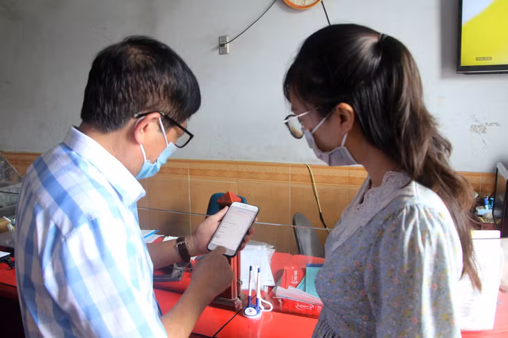 Ông Phạm Văn Nhữ, Tổ trưởng Tổ tự quản phòng, chống dịch Covid-19 số 8, khu 5 (phường Hồng Hải, TP Hạ Long) hướng dẫn người dân chủ động khai báo y tế.