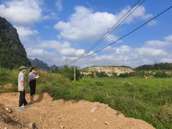 Ông Nguyễn Văn Tý, Bí thư Chi bộ, Trưởng thôn Đá Trắng (xã Thống Nhất), trao đổi với phóng viên về tình trạng ngập lụt, không thể canh tác được ở cánh đồng giữa ngầm Đá Trắng 1 và 2.