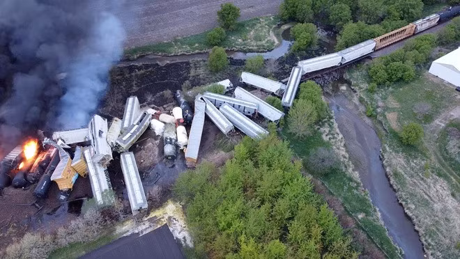 Các toa tàu xếp chồng lên nhau, trong khi một số toa bốc cháy sau vụ lật tàu ở bang Iowa. Ảnh: Reuters.