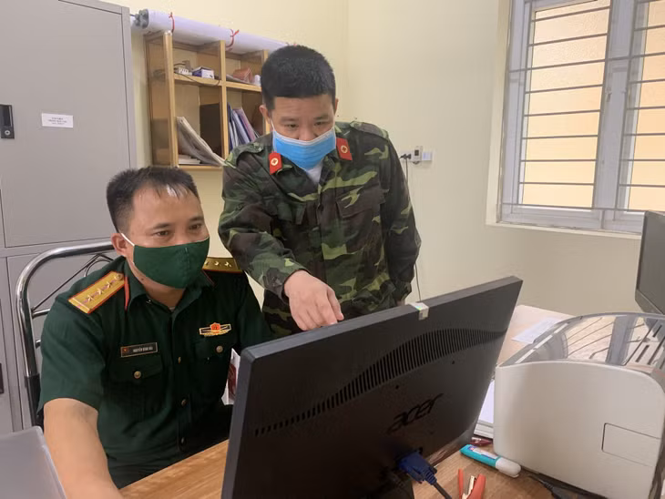 Thượng uý Nguyễn Đình Hải (bên trái) trao đổi công việc với đồng đội trong đơn vị.