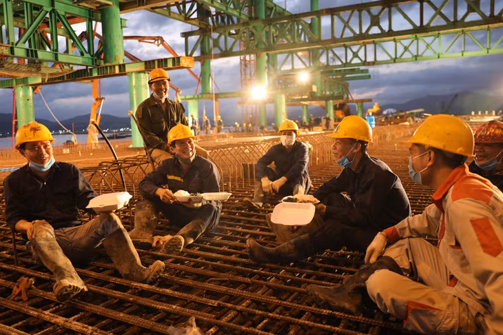 Công nhân ăn cơm giữa ca ngay trên công trường để đảm bảo thời gian cho việc thi công các hạng mục.