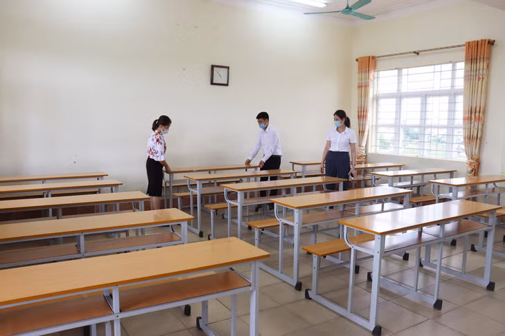 Cán bộ, giáo viên trường THPT Lê Chân (Đông Triều) lau dọn, kê lại bàn ghế chuẩn bị cho kỳ thi.