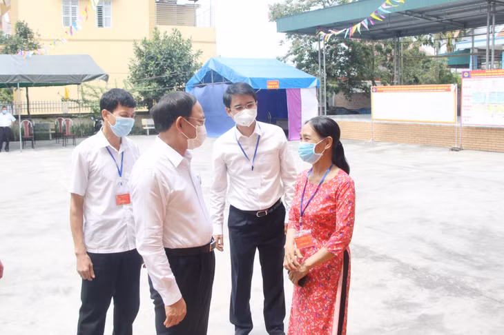 Ủy viên Trung ương Đảng, Bí thư Tỉnh ủy, Chủ tịch HĐND tỉnh Nguyễn Xuân Ký trao đổi với Tổ trưởng Tổ bầu cử Nguyễn Thị Chiến ở khu vực bỏ phiếu số 7 phường Hoàng Quế, TX Đông Triều (ngày 23/5/2021).