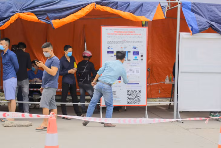 Người dân qua lại chốt cầu Đá Bạc cũng tích cực sử dụng khai báo y tế điện tử theo hướng dẫn trực quan bằng áp-phích được bố trí tại khu vực chốt.
