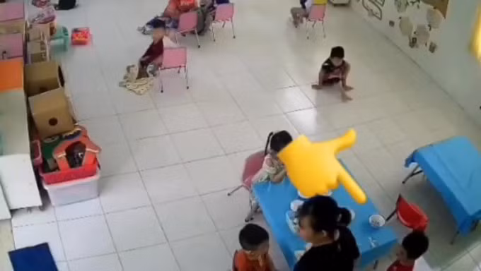 Cô giáo áo đen đứng dậy sau khi tát vào mặt bé trai. Ảnh chụp màn hình