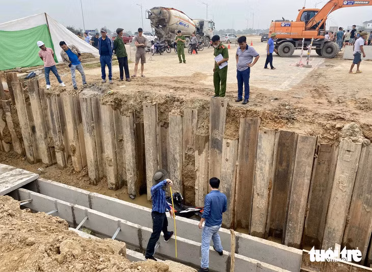 Lực lượng công an khám nghiệm hiện trường vụ nam thanh niên tử vong dưới hố công trình sáng 15/4 - Ảnh: DOÃN HÒA