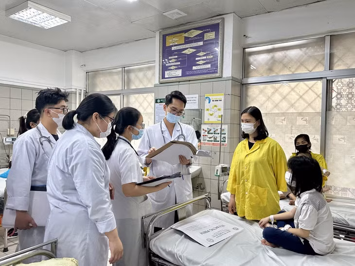 Bác sĩ Trung tâm Nhi khoa (Bệnh viện Bạch Mai) thăm khám một bệnh nhân (Ảnh: Hồng Hải).