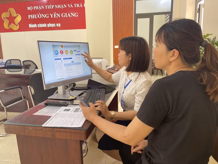 Cán bộ phường Yên Giang hướng dẫn người dân sử dụng cổng dịch vụ công trực tuyến.