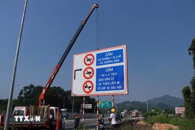Tổ chức cắm biển báo tại lối vào cao tốc Cam Lộ-La Sơn ở nút giao cầu Tuần. (Ảnh: Tường Vi/TTXVN)