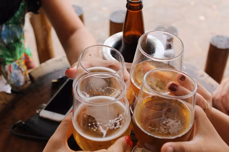 Uống nhiều bia rượu và ăn đồ dầu mỡ là một trong các lý do gây hại dạ dày. Ảnh: Unsplash.