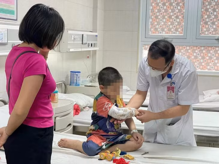 Bác sĩ Nguyễn Đức Lân - Trưởng khoa Ngoại nhi tổng hợp thăm khám cho bệnh nhi C. trước khi xuất viện. (Ảnh: PV/Vietnam+)