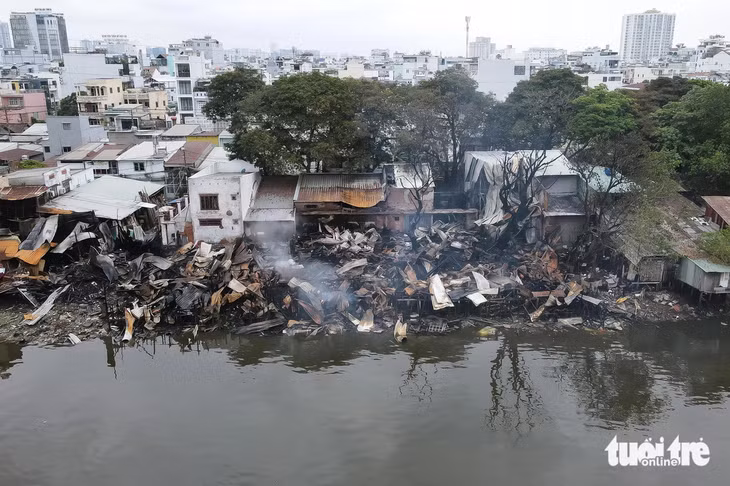 Cả dãy nhà ven kênh cháy đen, chỉ còn lại đống đổ nát - Ảnh: PHƯƠNG NHI