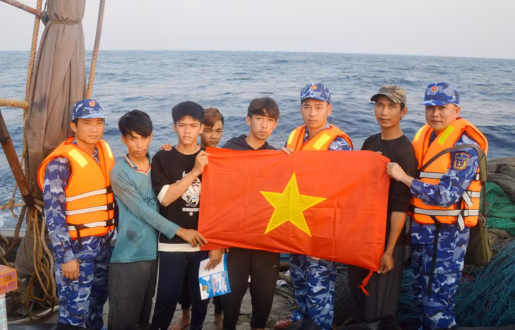 Lực lượng Cảnh sát biển Việt Nam tặng Cờ Tổ quốc cho ngư dân Việt Nam đánh bắt cá trên vùng biển lân cận đường phân định Vịnh Bắc Bộ. Ảnh: Mạnh Trường