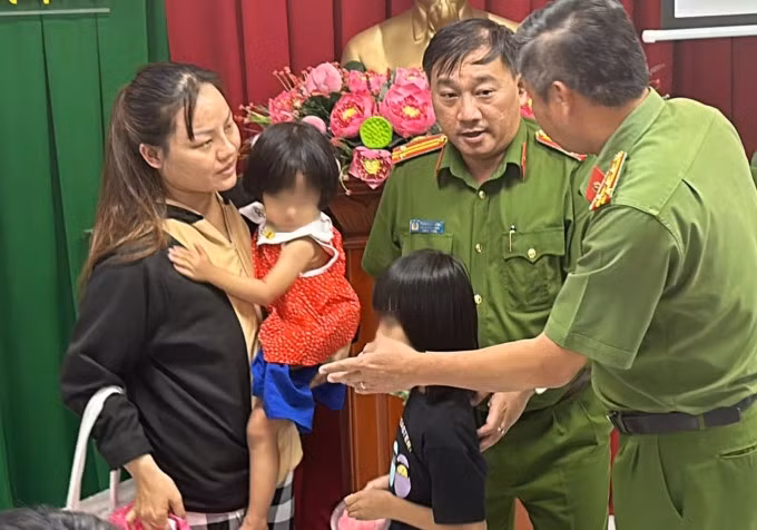 Cảnh sát giao 2 bé gái cho người mẹ. Ảnh: Quốc Thắng