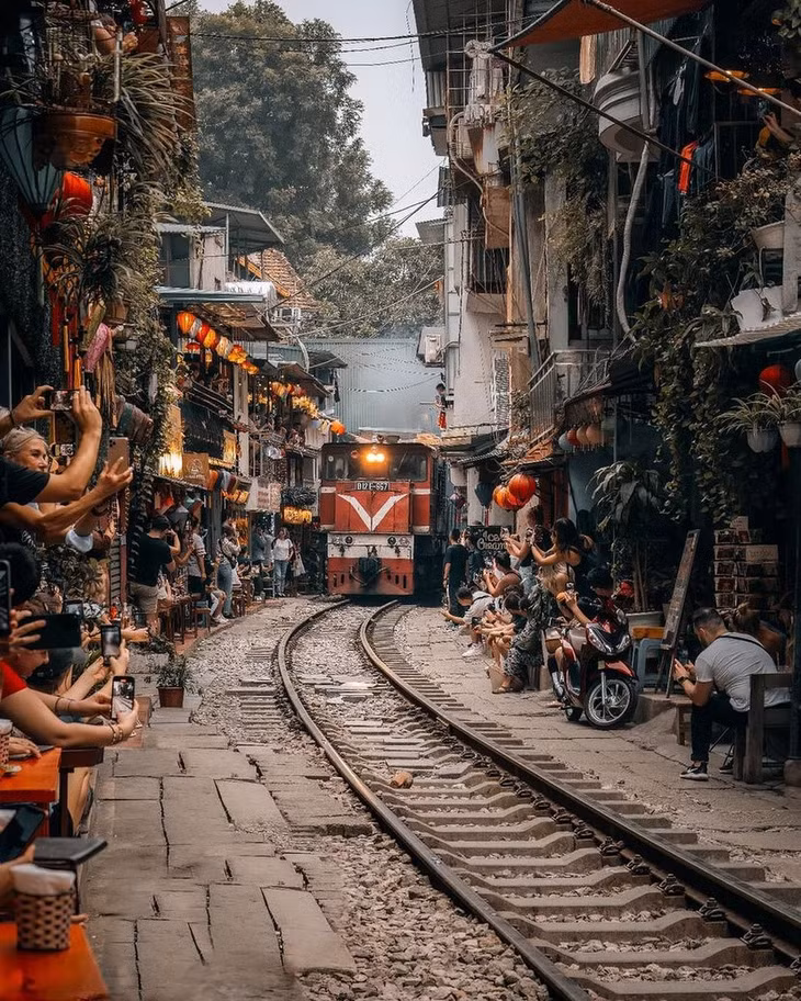 Nhiều du khách quốc tế thường xuyên đến phố đường tàu Hà Nội để tận hưởng không gian yên bình và ghi lại khoảnh khắc đặc biệt khi tàu chạy qua. Trong suốt 5 năm qua, cuộc "đấu trí" giữa chính quyền và du khách diễn ra không ngừng. Lo ngại về nguy cơ tai nạn nghiêm trọng, cơ quan chức năng tích cực thúc đẩy việc đóng cửa các quán cà phê ven đường từ năm 2019. Ảnh: @vietnamlocaladventures, @nature.rgb.