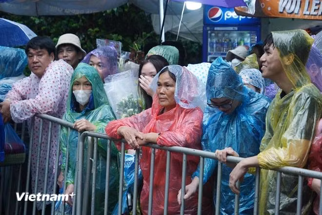 Bất chấp thời tiết đầu giờ sáng nay có mưa nặng hạt và gây không ít khó khăn cho việc di chuyển về dâng hương, tuy nhiên rất nhiều người dân từ khắp mọi miền Tổ quốc đã cùng đổ về Đền Hùng, chờ giờ mở cửa thắp nén hương thơm. (Ảnh: Việt Anh/Vietnam+)