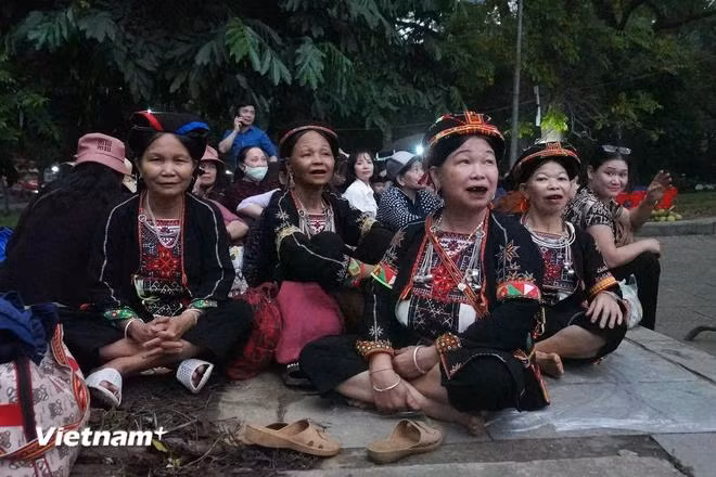 Bà Nguyễn Thị Tuyên (ngoài cùng bên trái) cùng đoàn hành hương 8 người dân tộc Dao (Tuyên Quang) ngồi chờ đến giờ hành hương. (Ảnh: Việt Anh/Vietnam+)