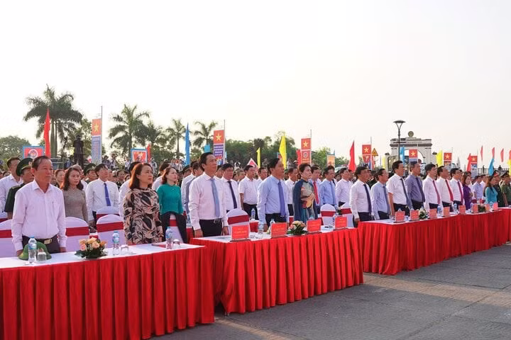 Các đại biểu, người dân làm lễ chào cờ và cùng ôn lại lịch sử hào hùng của dân tộc. (Ảnh: Nguyễn Luân).