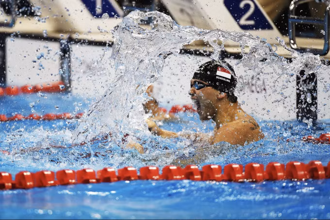 Joseph Schooling đập nước mừng khi giành HC vàng 100m bướm ở Olympic Rio 2016. Ảnh: NYT