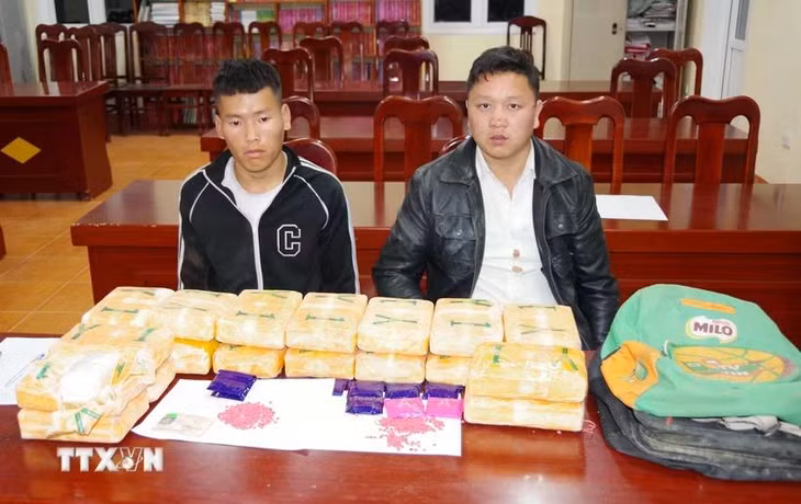 Đối tượng Thào A Già (bên trái) và Liều A Súa (bên phải) cùng tang vật vụ án. (Ảnh: TTXVN phát)
