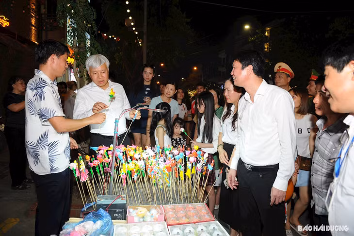 Đồng chí Lê Đình Long, Ủy viên Ban Thường vụ Tỉnh ủy, Bí thư Thành ủy Hải Dương (thứ hai từ trái qua) tham quan gian hàng bán tò he