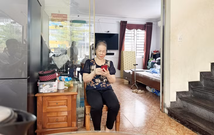 Bà Mai Kim Hường (khu 4, phường Hồng Hà, TP Hạ Long) kiểm tra số dư tài khoản ngân hàng nhận trợ cấp hằng tháng.