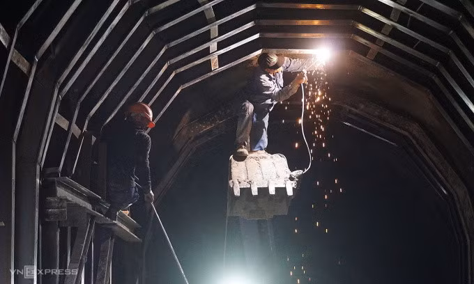 Công nhân hàn gia cố phía trên hầm trước khi cho tàu chạy thử tải, chiều 21/4. Ảnh: Bùi Toàn