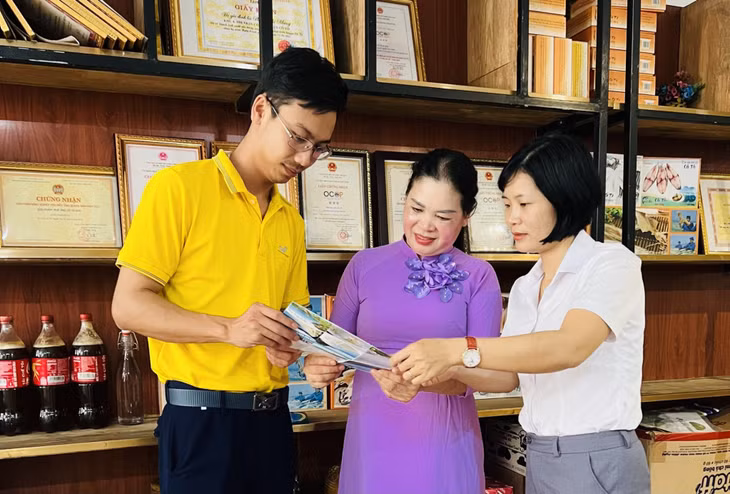 Cán bộ HND và nhân viên Bưu điện huyện hướng dẫn chị Phạm Thanh Măng (ở giữa) đưa sản phẩm lên sàn thương mại điện tử.