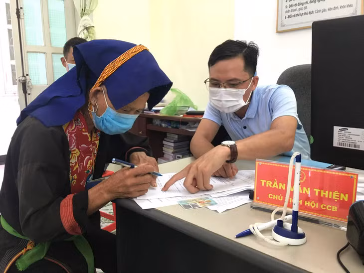 Cán bộ xã Đạp Thanh hướng dẫn người dân thực hiện thủ tục nhận kinh phí hỗ trợ.