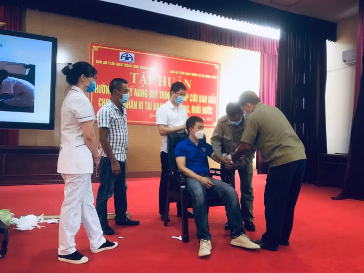 Các hướng dẫn viên hướng dẫn người dân cách sơ cấp cứu nạn nhân bị TNGT đúng cách.