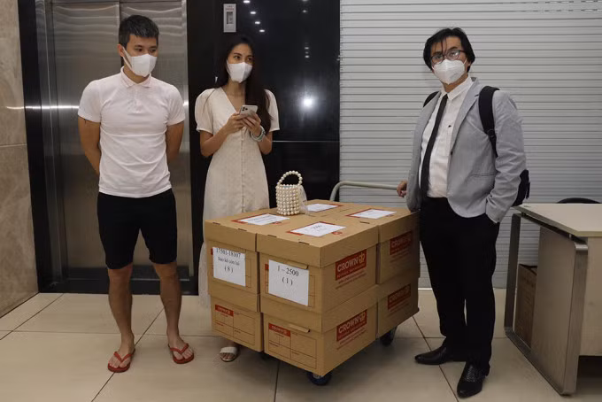 Vợ chồng Thủy Tiên - Công Vinh và luật sư đại diện của họ - ông Phan Vũ Tuấn - bên các thùng giấy đựng sao kê tại ngân hàng ở quận 7. Ảnh: Quỳnh Trần