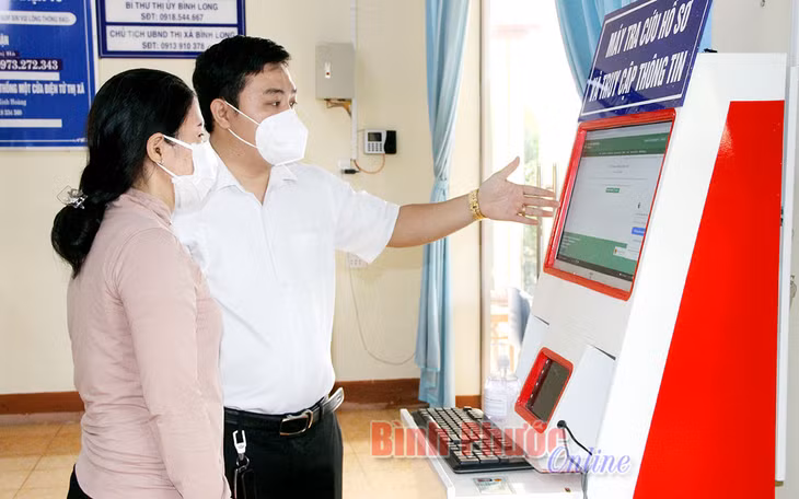 Công chức Bộ phận một cửa thị xã Bình Long hướng dẫn người dân, doanh nghiệp kết nối lên Cổng dịch vụ công của tỉnh để tra cứu và nộp hồ sơ trên môi trường mạng