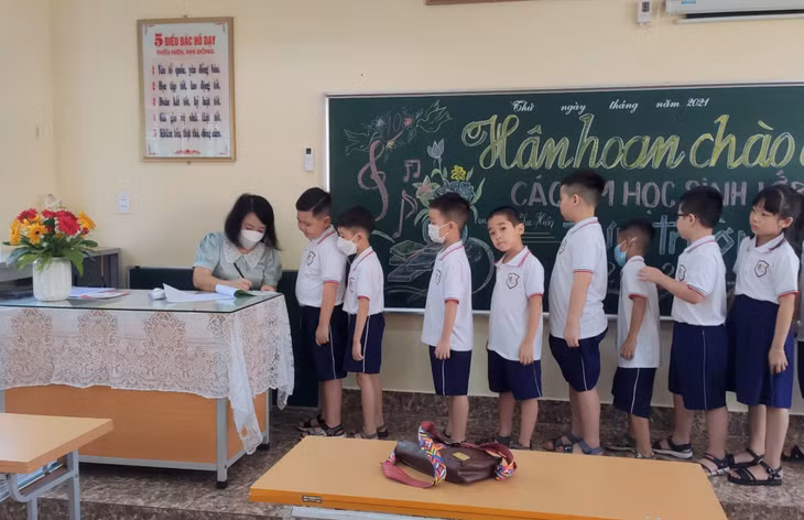Tại Trường Tiểu học Lê Hồng Phong (TP Hạ Long), sau các bước đảm bảo an toàn phòng dịch từ cổng trường, các thầy cô giáo tiếp tục kiểm tra thân nhiệt, ghi thông tin sức khỏe của học sinh tại lớp học.