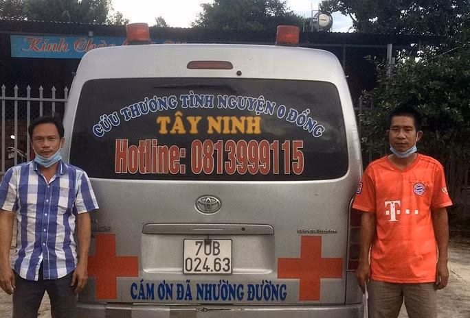 Ông Trần Hùng Thanh (trái) cùng chiếc xe cứu thương mà mình cầm lái. (Ảnh: Công an cung cấp)