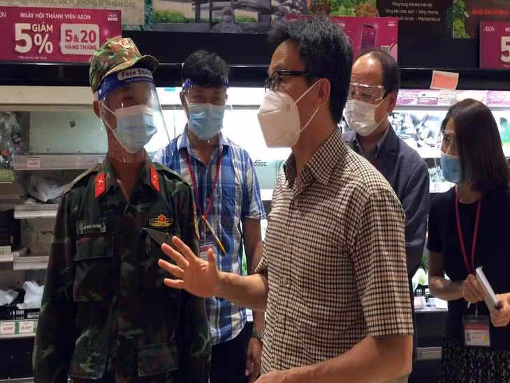 Phó Thủ tướng trò chuyện với một chiến sĩ “đi chợ hộ” cho người dân. Ảnh VGP/Đình Nam
